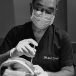 Doctor performing a hair transplant procedure on a patient.